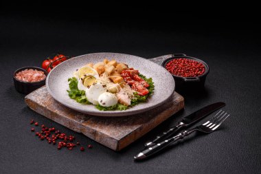 Marullu taze salata, kızarmış ekmek, tavuk filetosu, domatesler ve koyu beton arka planda yumurta.