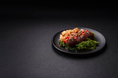 Lezzetli kızarmış falafel nohuttan, kimyondan, tuzlu humus ve baharatlı koyu beton arka planda.