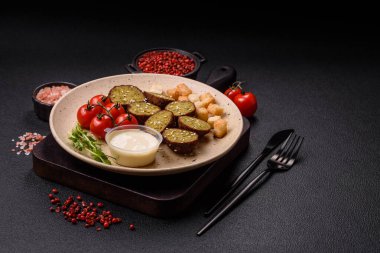 Lezzetli kızarmış falafel nohuttan, kimyondan, tuzlu humus ve baharatlı koyu beton arka planda.