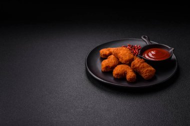 Delicious fresh crispy chicken nuggets on a dark concrete background. Unhealthy food, fast food