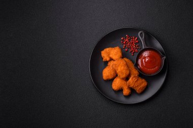 Delicious fresh crispy chicken nuggets on a dark concrete background. Unhealthy food, fast food