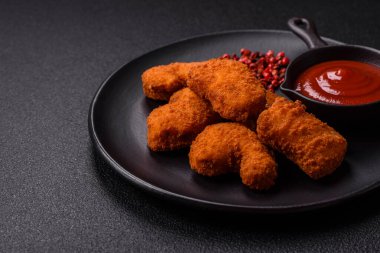 Delicious fresh crispy chicken nuggets on a dark concrete background. Unhealthy food, fast food