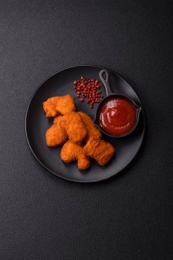 Delicious fresh crispy chicken nuggets on a dark concrete background. Unhealthy food, fast food