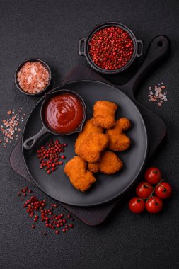Delicious fresh crispy chicken nuggets on a dark concrete background. Unhealthy food, fast food