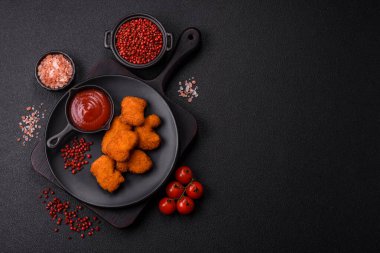 Delicious fresh crispy chicken nuggets on a dark concrete background. Unhealthy food, fast food