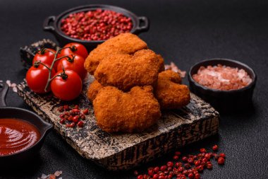 Delicious fresh crispy chicken nuggets on a dark concrete background. Unhealthy food, fast food