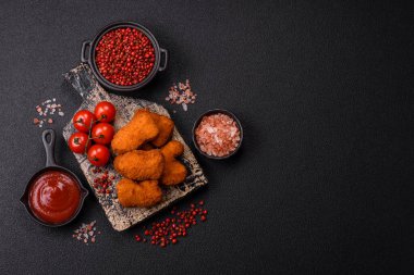 Delicious fresh crispy chicken nuggets on a dark concrete background. Unhealthy food, fast food