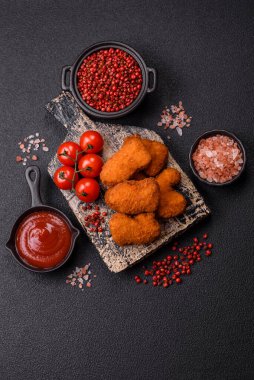 Delicious fresh crispy chicken nuggets on a dark concrete background. Unhealthy food, fast food