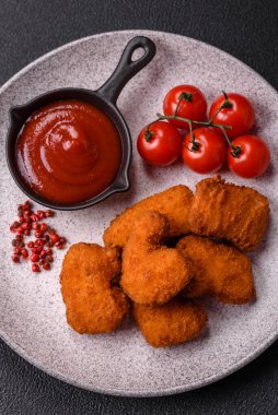 Delicious fresh crispy chicken nuggets on a dark concrete background. Unhealthy food, fast food