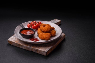 Delicious fresh crispy chicken nuggets on a dark concrete background. Unhealthy food, fast food
