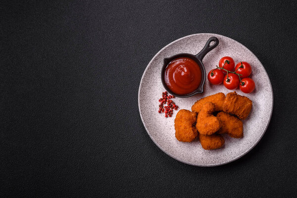 Вкусные свежие хрустящие куриные наггетсы на темном бетонном фоне. Нездоровое питание, фаст-фуд