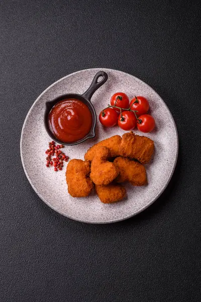 Koyu beton arka planda lezzetli çıtır tavuk nuggetları. Sağlıksız yemek, fast food