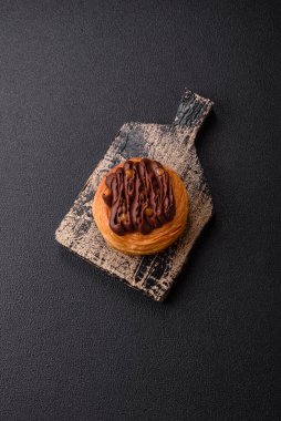 Koyu beton bir arka planda kremayla kaplı tatlı Danimarka çöreği.