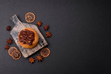 Koyu beton bir arka planda kremayla kaplı tatlı Danimarka çöreği.