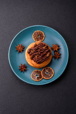 Koyu beton bir arka planda kremayla kaplı tatlı Danimarka çöreği.