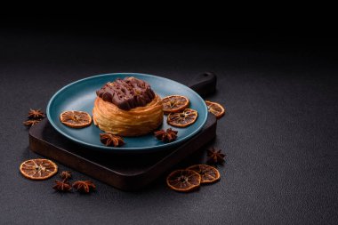 Koyu beton bir arka planda kremayla kaplı tatlı Danimarka çöreği.