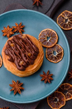 Koyu beton bir arka planda kremayla kaplı tatlı Danimarka çöreği.