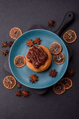 Koyu beton bir arka planda kremayla kaplı tatlı Danimarka çöreği.