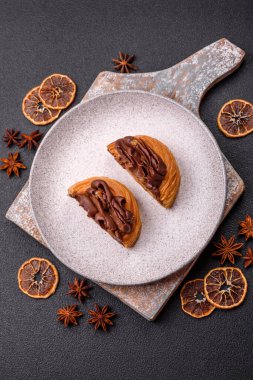 Koyu beton bir arka planda kremayla kaplı tatlı Danimarka çöreği.