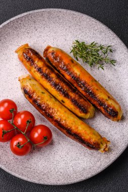 Koyu beton arka planda tuz, baharat ve otlu tavuk veya domuz sosisi.