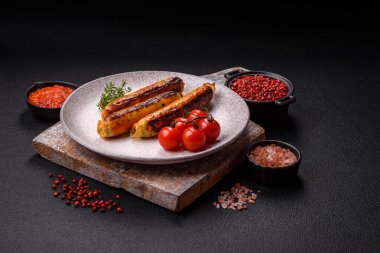 Koyu beton arka planda tuz, baharat ve otlu tavuk veya domuz sosisi.