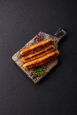 Koyu beton arka planda tuz, baharat ve otlu tavuk veya domuz sosisi.