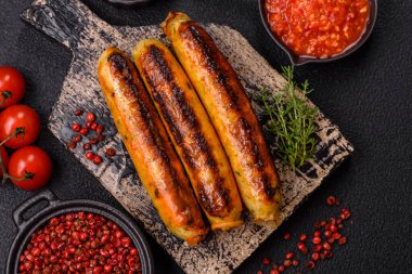 Koyu beton arka planda tuz, baharat ve otlu tavuk veya domuz sosisi.