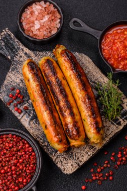 Koyu beton arka planda tuz, baharat ve otlu tavuk veya domuz sosisi.