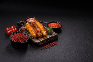 Koyu beton arka planda tuz, baharat ve otlu tavuk veya domuz sosisi.