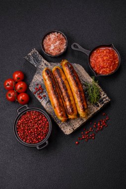 Koyu beton arka planda tuz, baharat ve otlu tavuk veya domuz sosisi.