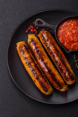 Koyu beton arka planda tuz, baharat ve otlu tavuk veya domuz sosisi.