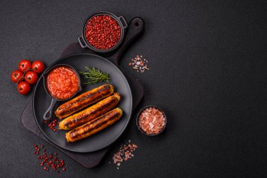 Koyu beton arka planda tuz, baharat ve otlu tavuk veya domuz sosisi.