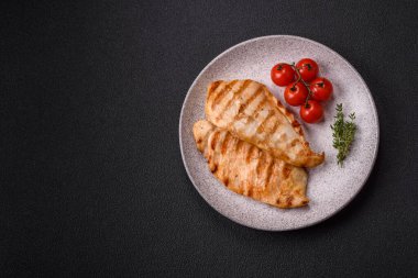 Lezzetli taze ızgara tavuk filetosu, esrarlı baharatlar ve çimento kaplı otlar. Ateşte pişirilmiş bir tabak.