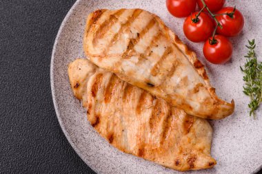 Lezzetli taze ızgara tavuk filetosu, esrarlı baharatlar ve çimento kaplı otlar. Ateşte pişirilmiş bir tabak.