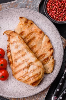 Lezzetli taze ızgara tavuk filetosu, esrarlı baharatlar ve çimento kaplı otlar. Ateşte pişirilmiş bir tabak.