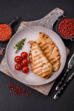 Lezzetli taze ızgara tavuk filetosu, esrarlı baharatlar ve çimento kaplı otlar. Ateşte pişirilmiş bir tabak.