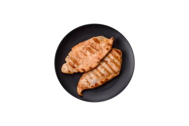 Beyaz arka planda baharat ve bitkilerle nefis taze ızgara tavuk filetosu. Ateşte pişirilmiş bir tabak.