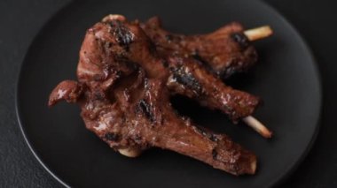 Izgarada pişmiş biftek, tuz, baharat ve otlarla birlikte koyu beton bir arka planda.