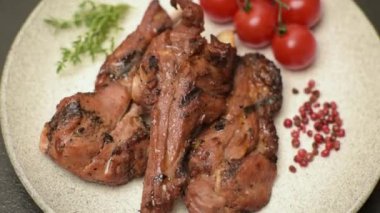 Izgarada pişmiş biftek, tuz, baharat ve otlarla birlikte koyu beton bir arka planda.