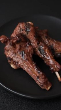 Izgarada pişmiş biftek, tuz, baharat ve otlarla birlikte koyu beton bir arka planda.