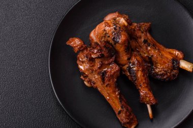 Izgarada pişmiş biftek, tuz, baharat ve otlarla birlikte koyu beton bir arka planda.