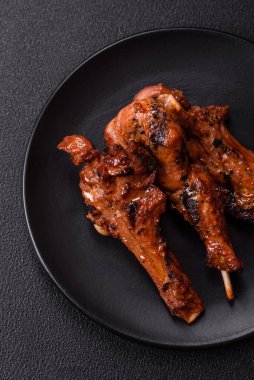 Izgarada pişmiş biftek, tuz, baharat ve otlarla birlikte koyu beton bir arka planda.