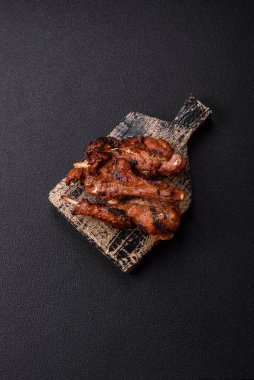 Izgarada pişmiş biftek, tuz, baharat ve otlarla birlikte koyu beton bir arka planda.