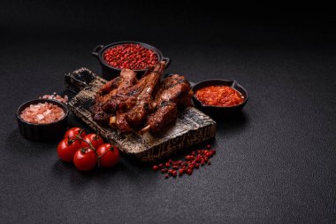 Izgarada pişmiş biftek, tuz, baharat ve otlarla birlikte koyu beton bir arka planda.