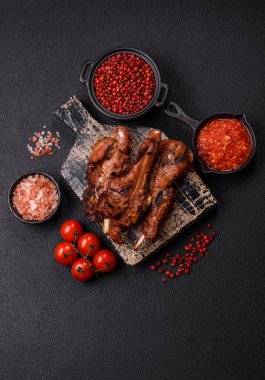 Izgarada pişmiş biftek, tuz, baharat ve otlarla birlikte koyu beton bir arka planda.