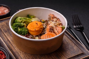 Tuz ve baharatlı ızgara somon, brokoli, domates, koyu beton arka planda pirinç.