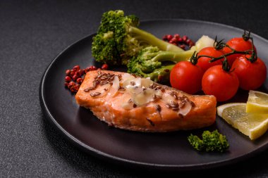 Tuz ve baharatlı ızgara somon, brokoli, domates, koyu beton arka planda pirinç.