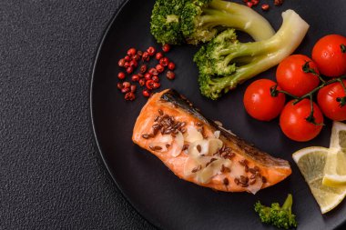 Tuz ve baharatlı ızgara somon, brokoli, domates, koyu beton arka planda pirinç.