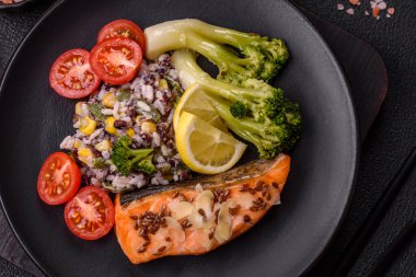 Tuz ve baharatlı ızgara somon, brokoli, domates, koyu beton arka planda pirinç.