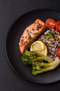 Tuz ve baharatlı ızgara somon, brokoli, domates, koyu beton arka planda pirinç.